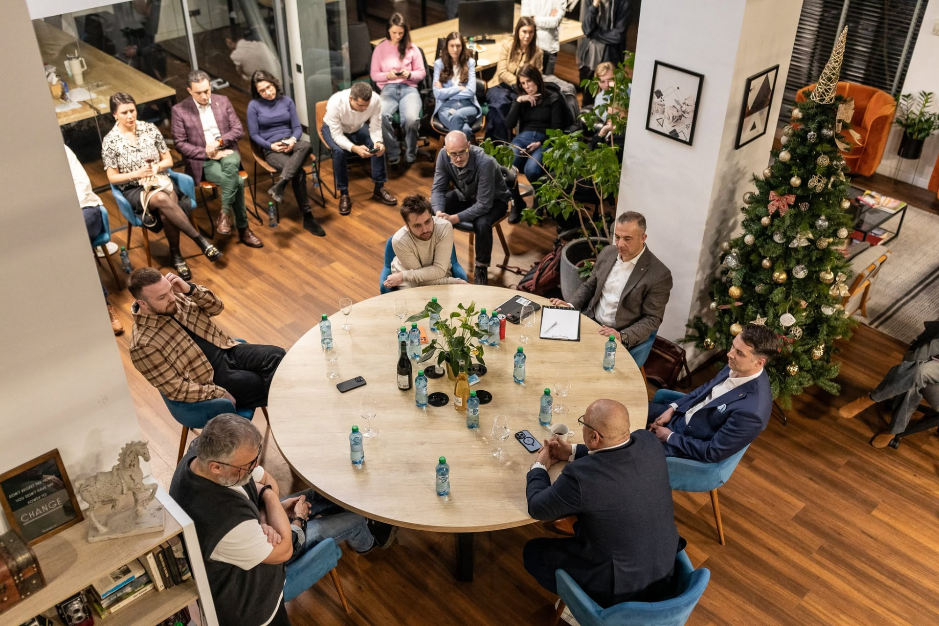Senior professionals in focused discussion around a long table in a bright room.